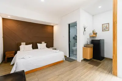a bedroom with a large bed and a bathroom at Griya Sadhana Dewi Sri in Legian