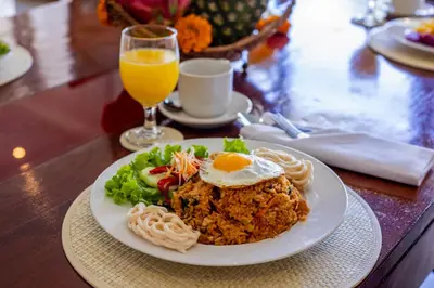 a plate of food on a table with an egg on top at Villa Isabella in Seminyak