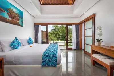 a bedroom with a large bed and a desk at Villa Isabella in Seminyak