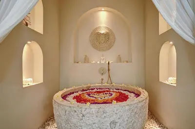 a large stone tub with a flower arrangement in a room at The Medusa Villas Bali in Seminyak