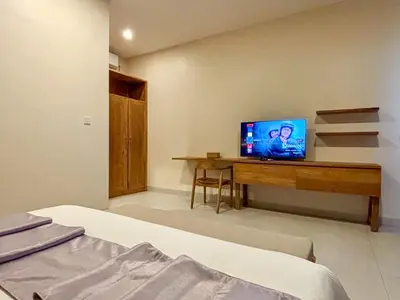 a bedroom with a desk with a television on it at Solvana Villas Sanur by AGATA in Sanur