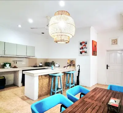 a kitchen with a wooden table and blue bar stools at Villa bunny seminyak in Seminyak