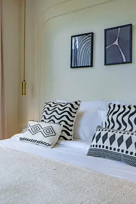 a bed with black and white pillows on it at Casa Samudra - 3BR Villa in Seminyak in Seminyak