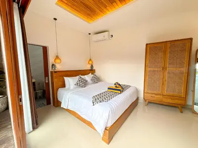 a bedroom with a large bed with white sheets at The Abian Villa Seminyak in Seminyak