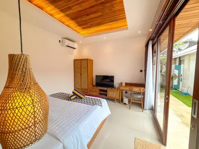 a bedroom with a bed and a television in a room at The Abian Villa Seminyak in Seminyak