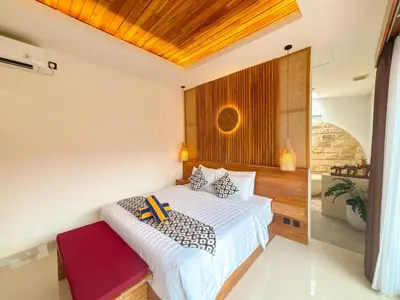 a bedroom with a large white bed in a room at The Abian Villa Seminyak in Seminyak