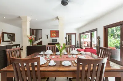 a dining room with a wooden table and chairs at Villa Sedap Malam - Private 2 Bedroom Villa Near Seminyak Beach in Kuta