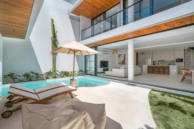 a house with a pool and a living room at Villa Janoor by GORO in Canggu