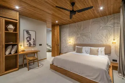 a bedroom with a large bed and a desk at Villa Bayu by GORO in Canggu