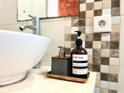 a bottle of hair soap sitting on a counter next to a sink at Modern Guesthouse in Seminyak in Seminyak