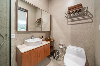 a bathroom with a sink and a toilet and a mirror at Umaliving Villa Seminyak Bali in Seminyak