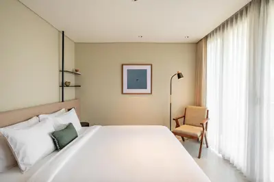 a bedroom with a bed and a chair and a window at Villa Mesra Stunning Paddy Fields Views - Canggu Berawa in Canggu