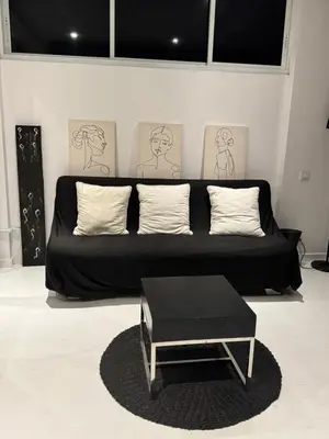 a black couch with pillows and a table in a room at Minimalist apartment long term in Seminyak