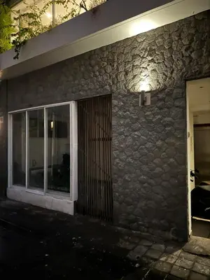 a building with a stone wall with a door at Minimalist apartment long term in Seminyak