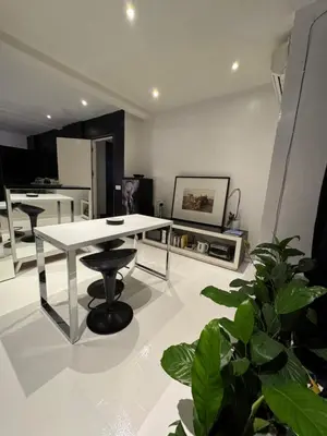 a living room with a white table and some plants at Minimalist apartment long term in Seminyak