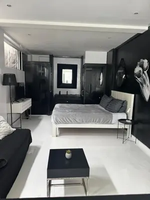a bedroom with a bed and a table in it at Minimalist apartment long term in Seminyak