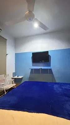 a bedroom with a bed with a blue wall at A Room in Santorini House Room Near Airport Bali in Kuta