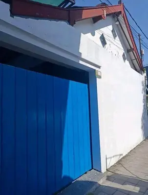 a blue garage door on the side of a building at A Room in Santorini House Room Near Airport Bali in Kuta