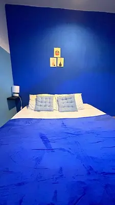 a blue bedroom with a bed with blue walls at A Room in Santorini House Room Near Airport Bali in Kuta
