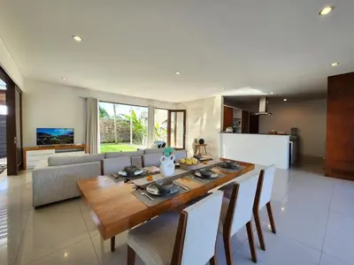 a kitchen and dining room with a wooden table and chairs at Villa Abigail Seminyak by Nagisa Bali in Seminyak
