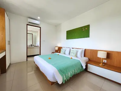 a bedroom with a large bed in a room at Villa Abigail Seminyak by Nagisa Bali in Seminyak