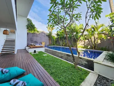 a small backyard with a swimming pool and a wooden deck at Villa Abigail Seminyak by Nagisa Bali in Seminyak