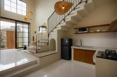 a kitchen with a spiral staircase in a house at Villa Batu Putih 2 Seminyak - No FLOOD in Seminyak