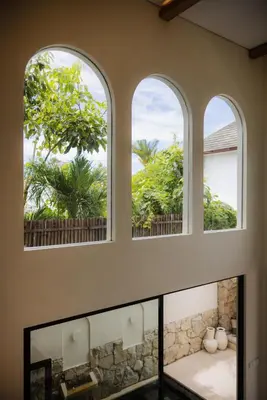three windows in a room with a view of trees at Villa Batu Putih 2 Seminyak - No FLOOD in Seminyak