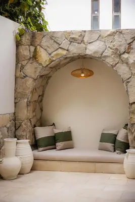 a bench in a stone wall with pillows at Villa Batu Putih 2 Seminyak - No FLOOD in Seminyak