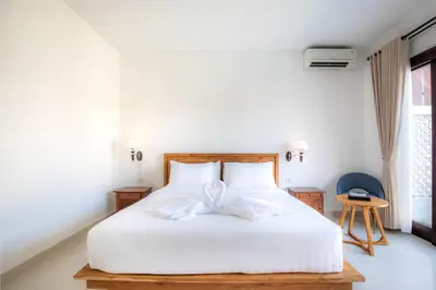 a bedroom with a white bed with a bow on it at Cherish Villa Umalas in Canggu