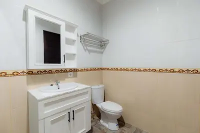 a bathroom with a toilet and a sink and a mirror at Cherish Villa Umalas in Canggu