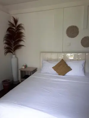 a white bed with a pillow on top of it at Seminyak great Location Villa in Seminyak
