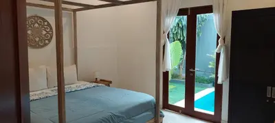 a bedroom with a bed and a sliding glass door at Seminyak great Location Villa in Seminyak