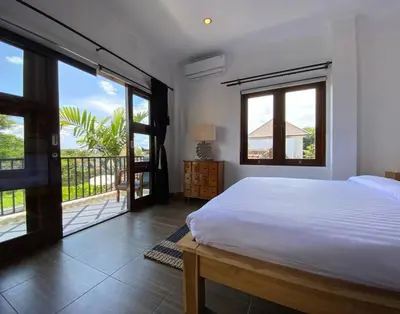 a bedroom with a white bed and a balcony at Amazing Villa in Seminyak Petitenget Top Location in Seminyak