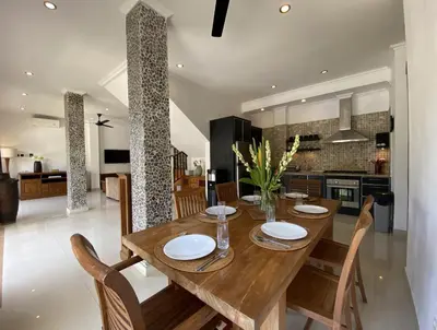a dining room with a wooden table and chairs at Amazing Villa in Seminyak Petitenget Top Location in Seminyak