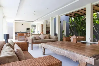 a living room with a couch and a wooden table at Villa Bteega sawah in Seminyak