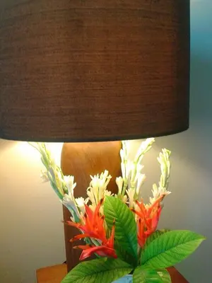 a lamp with a vase of flowers on a table at Villa Bteega sawah in Seminyak