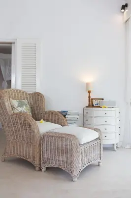 a wicker chair and ottoman in a living room at Bear Cottage 4 Bedroom Luxury Villa - Petitenget, Seminyak in Seminyak