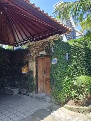 a brick house with a wooden door and ivy at Bear Cottage 4 Bedroom Luxury Villa - Petitenget, Seminyak in Seminyak