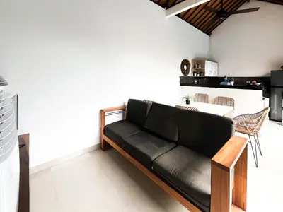 a black couch in a living room with a table at Villa Kita Seminyak in Seminyak
