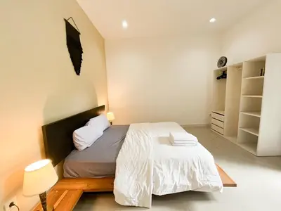 a bedroom with a bed with a wooden headboard at Villa Kita Seminyak in Seminyak