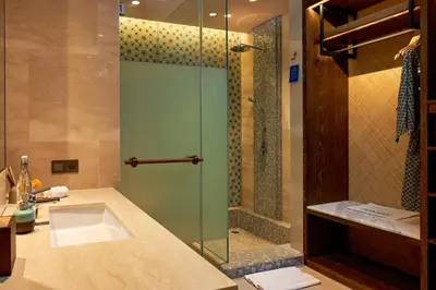a bathroom with a sink and a glass shower at Aahana Village Bali in Canggu