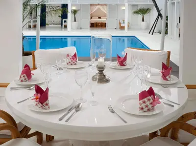 a white table with plates and wine glasses on it at Villa Lulito in Seminyak