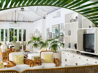 a living room with white furniture and a flat screen tv at Villa Lulito in Seminyak