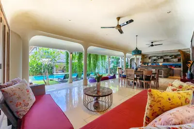 a living room with a red couch and a table at Villa Sky Li by Nagisa Bali in Seminyak
