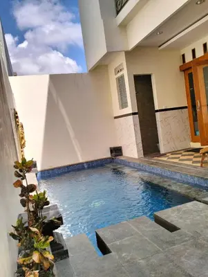 a swimming pool in the middle of a house at Villa Sanur2 in Sanur