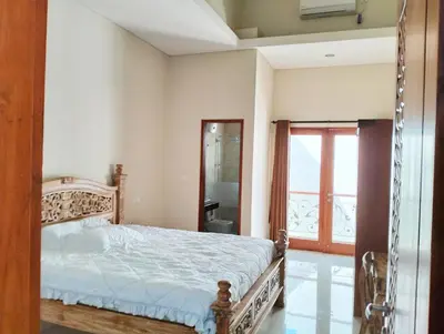 a bedroom with a bed and a bathroom with a window at Villa Sanur2 in Sanur