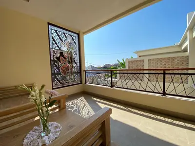 a balcony with a stained glass window and a vase with flowers at Villa Sanur 3 in Sanur