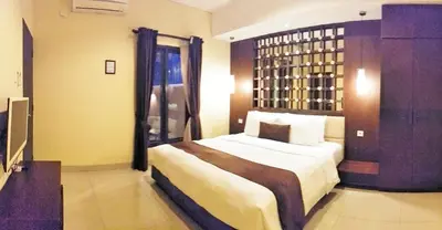 a bedroom with a large bed and a window at Maya Kori Villa in Jimbaran