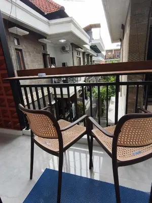a pair of chairs sitting on a balcony at Jepun Segara Guest House in Kuta